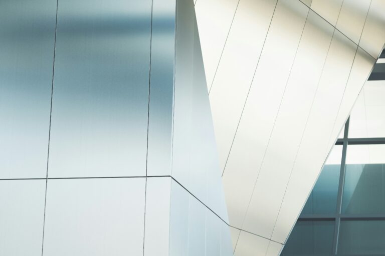 Moderne Architektur mit glatten, grauen Metallfassaden und scharfen geometrischen Linien.